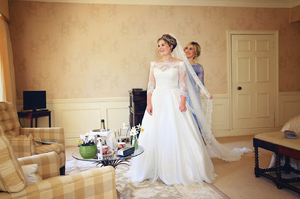 Bride and mum in grand bedroom before wedding ceremony 