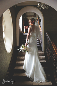 Bride on staircase looking through a widow