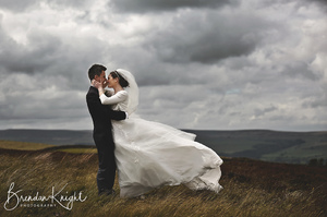 bride and groom hugging on a very windy day at Pen hill North Yorkshire