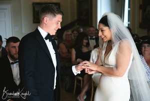 groom receiving a wedding ring from his bride