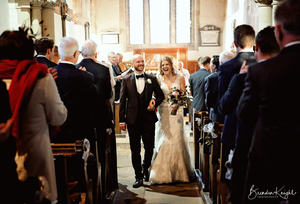 Bride and groom walk down the aisle in church