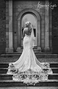 Bride stood on outside staircase showing the back of her dress