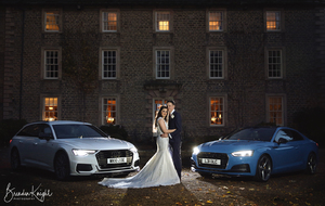 bride and groom with two Audi cars at night