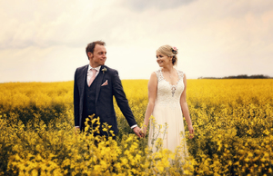bride and groom in an oilseed rape field