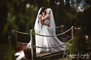 bride and bride on a small bridge kissing and hugging