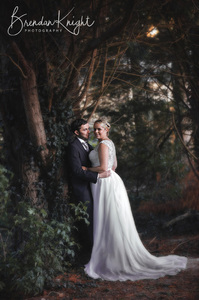 bride and groom hugging next to a tree